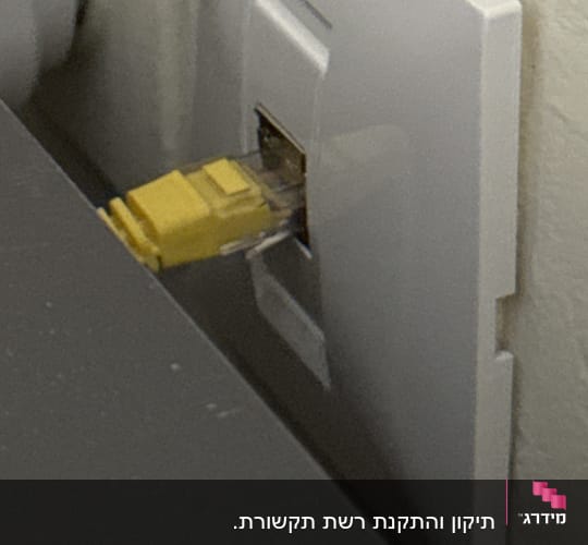 כבל רשת מחובר לשקע בקיר